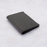 Black Paguro Upcycle recycled rubber wallet with textured surface folded on a light background